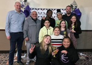 Photo of girls holding up trophies at banquet